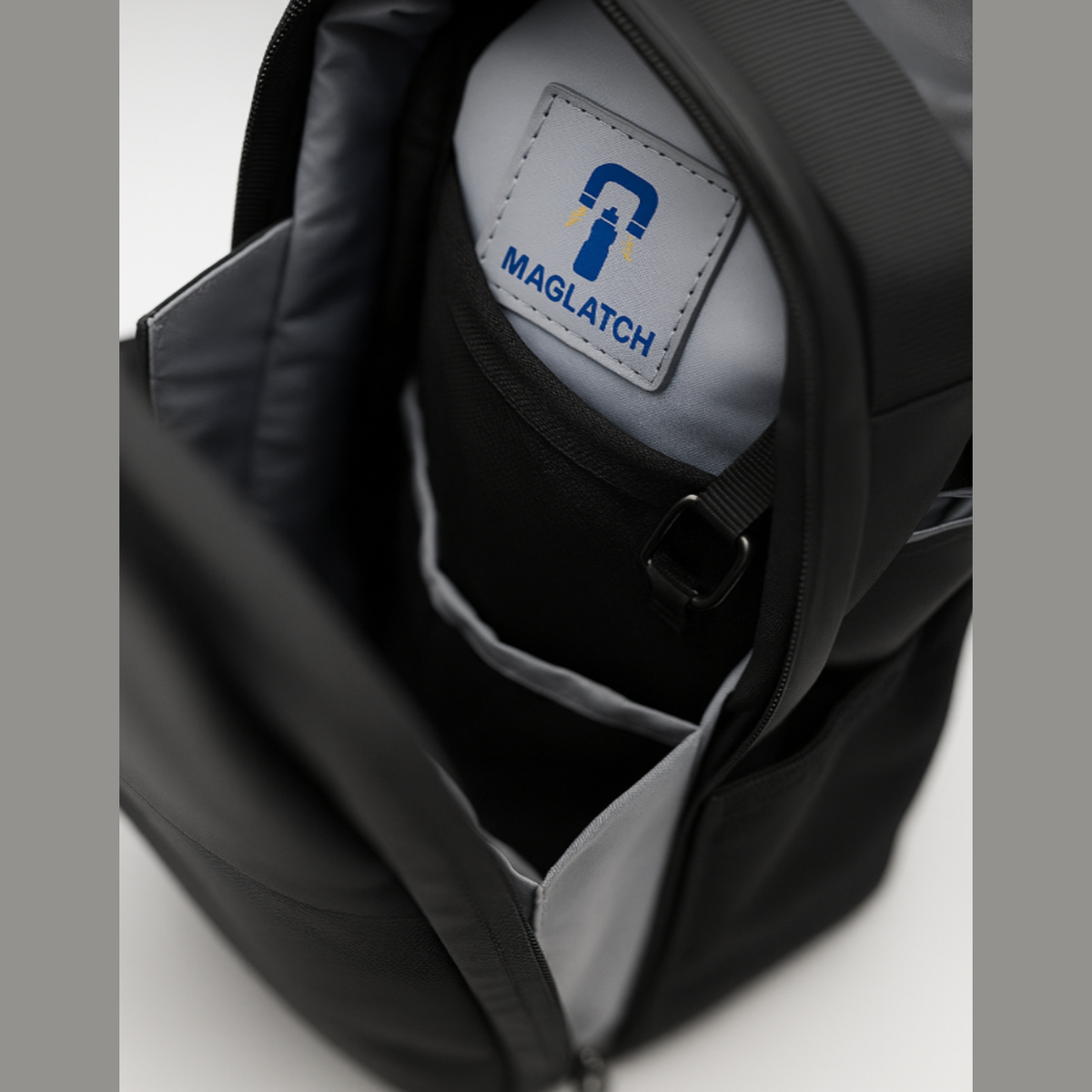 Close-up of a black bag with a Maglatch logo on a white background